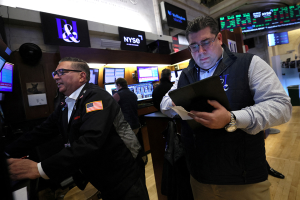 FILE PHOTO: Traders work on the floor at the New York Stock Exchange (NYSE) in New York City, U.S., March 20, 2024. REUTERS/Brendan McDermid/File Photo