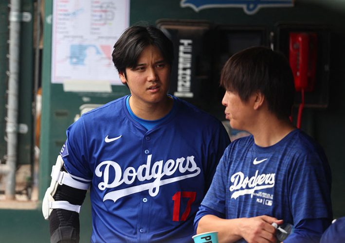 Mar 12, 2024; Phoenix, Arizona, USA; Los Angeles Dodgers designated hitter Shohei Ohtani talks with translator Ippei Mizuhara in the dugout against the San Francisco Giants during a spring training baseball game at Camelback Ranch-Glendale. Mandatory Credit: Mark J. Rebilas-USA TODAY Sports